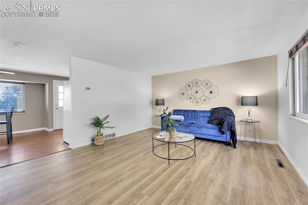 Image 6 of 36: Living area with wood finished floors and baseboards