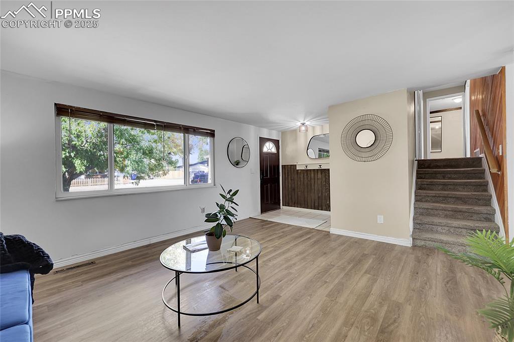 Image 8 of 36: Living area featuring light wood-style floors and stairway