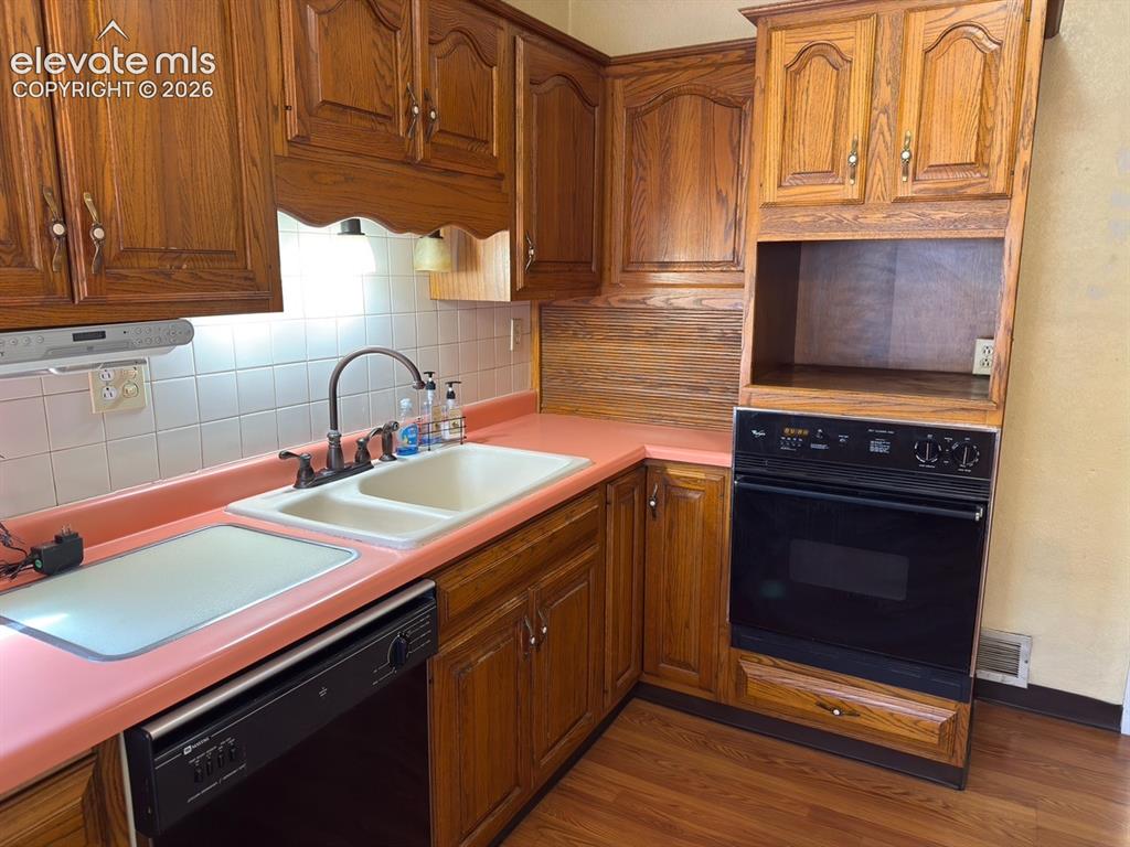 Image 33 of 48: Kitchen featuring wood cabinetry, a double basin sink, and an integrated wa