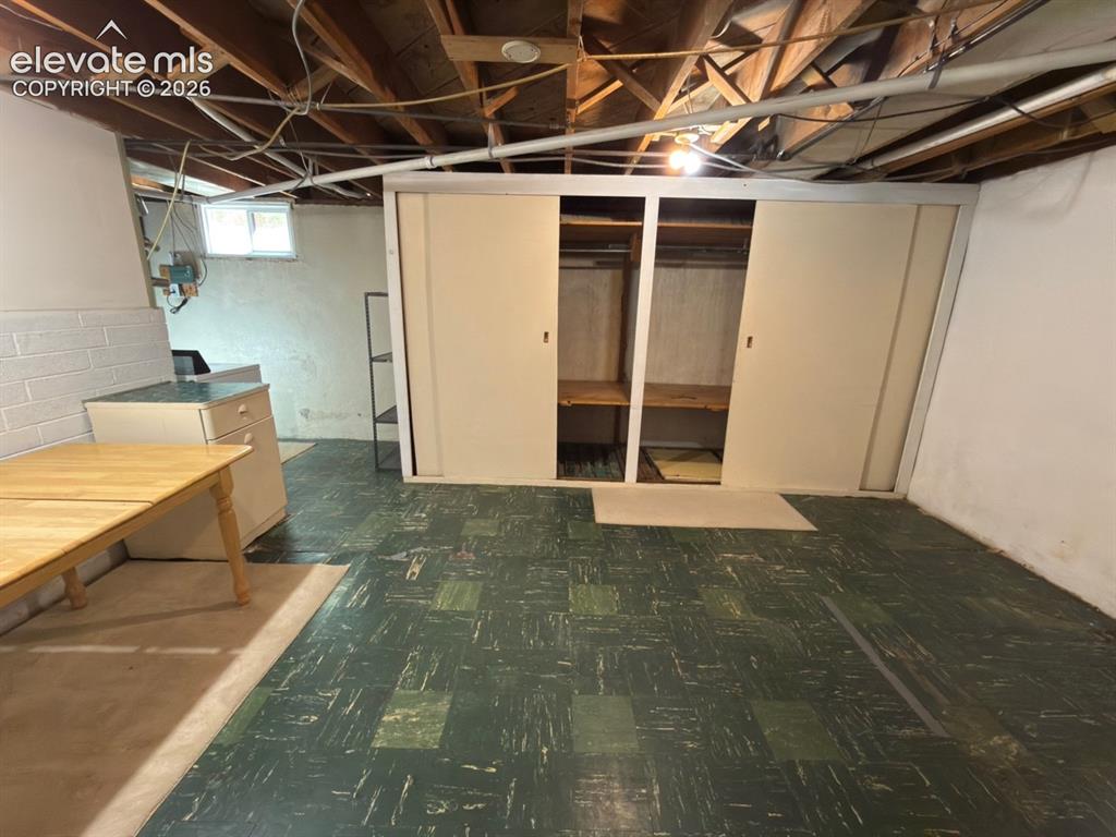Image 35 of 48: Basement space featuring exposed ceiling joists and utilities, patterned re