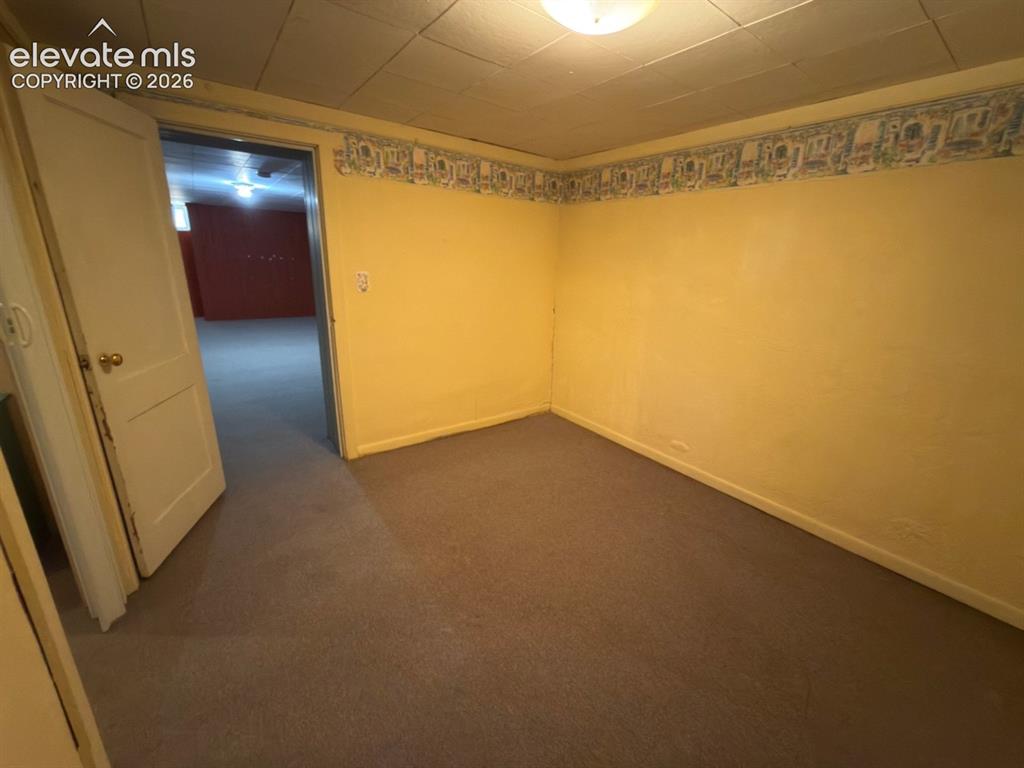 Image 38 of 48: Room featuring yellow painted walls, patterned wallpaper border, and neutra