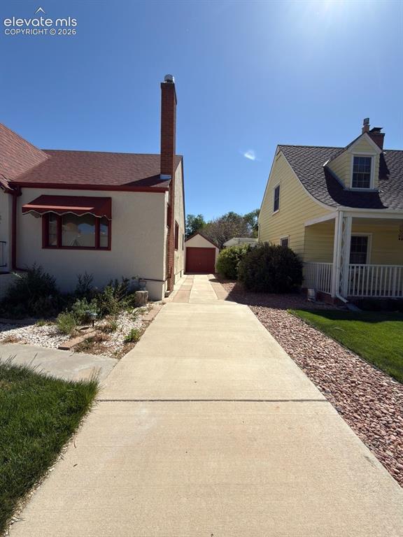 Image 41 of 48: Long concrete driveway extending toward a detached garage