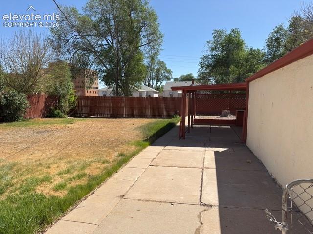 Image 44 of 48: Expansive backyard featuring a concrete patio, wooden pergola, and a privat