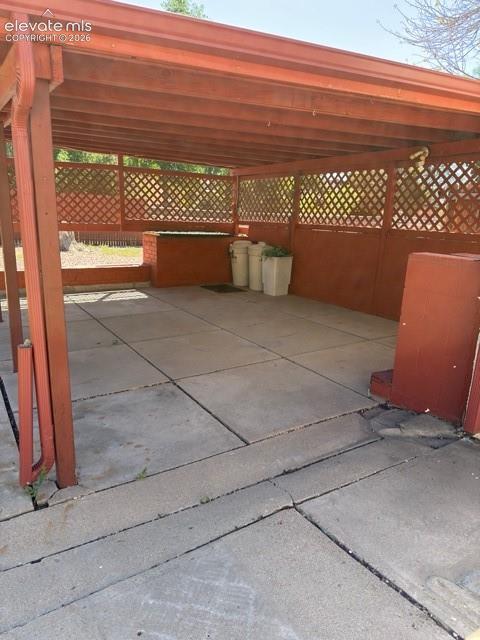 Image 45 of 48: Covered patio space featuring a wood-frame structure and lattice detailing