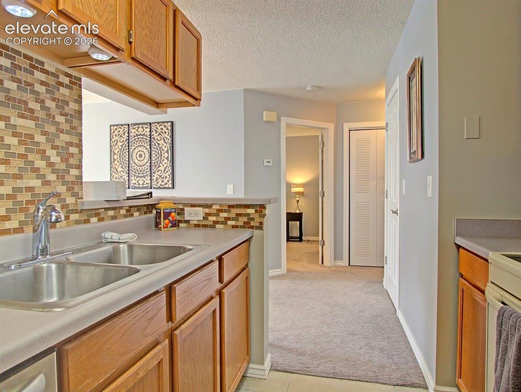 Image 10 of 13: Kitchen featuring wood cabinetry, a double basin stainless steel sink with 