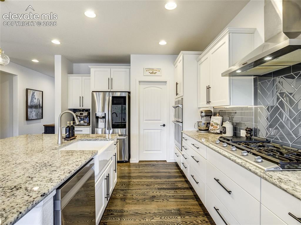 Image 15 of 50: Stainless appliances, double oven & oversized cooktop give the home chef pl