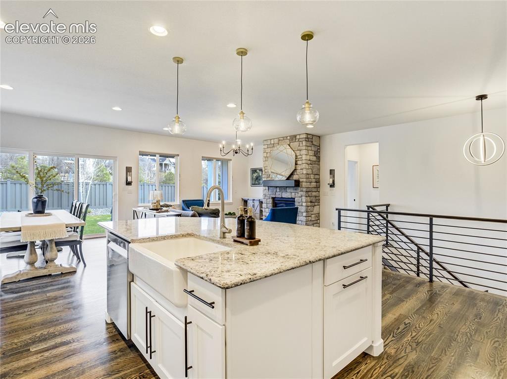 Image 16 of 50: The large center island features a farm sink, granite countertop, upgraded