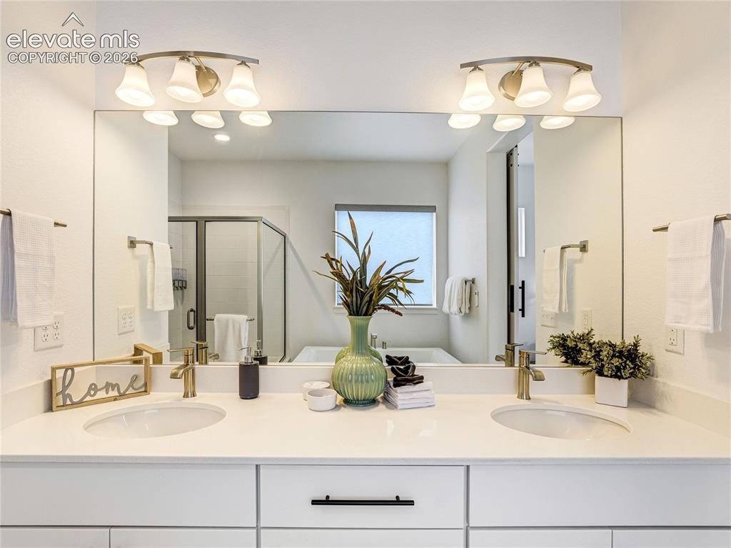 Image 24 of 50: Crisp white counter & cabinetry in the primary en-suite create the perfect