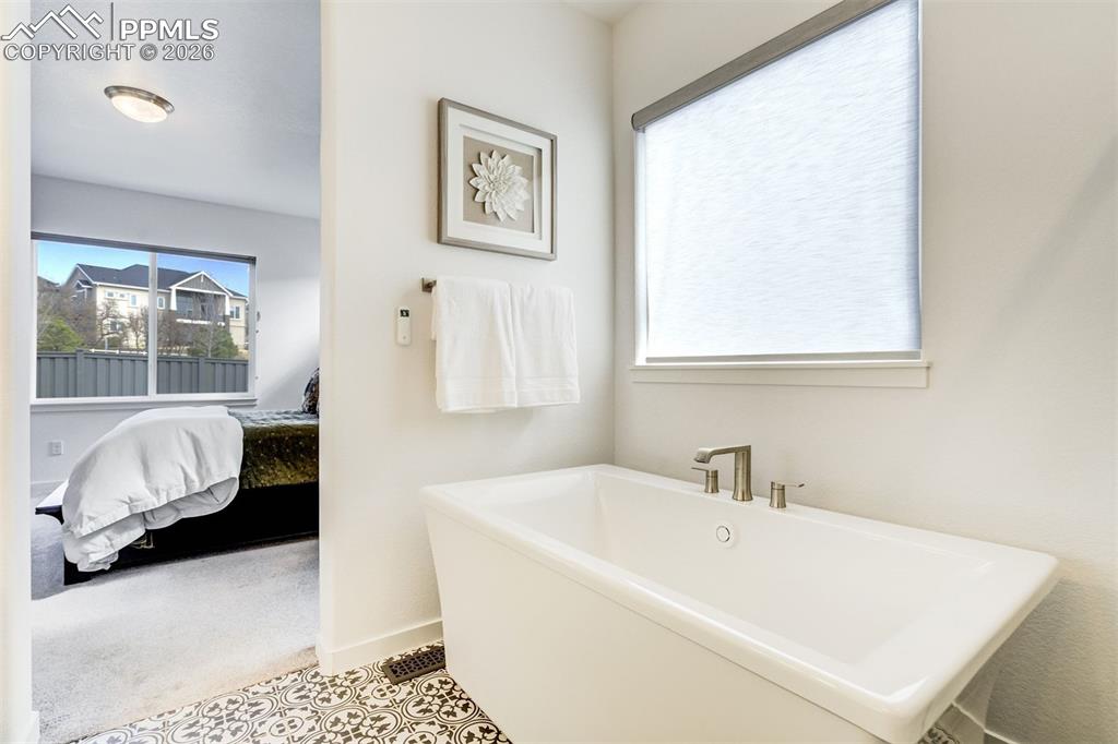 Image 25 of 46: The main-level primary suite is the perfect place for quiet & privacy