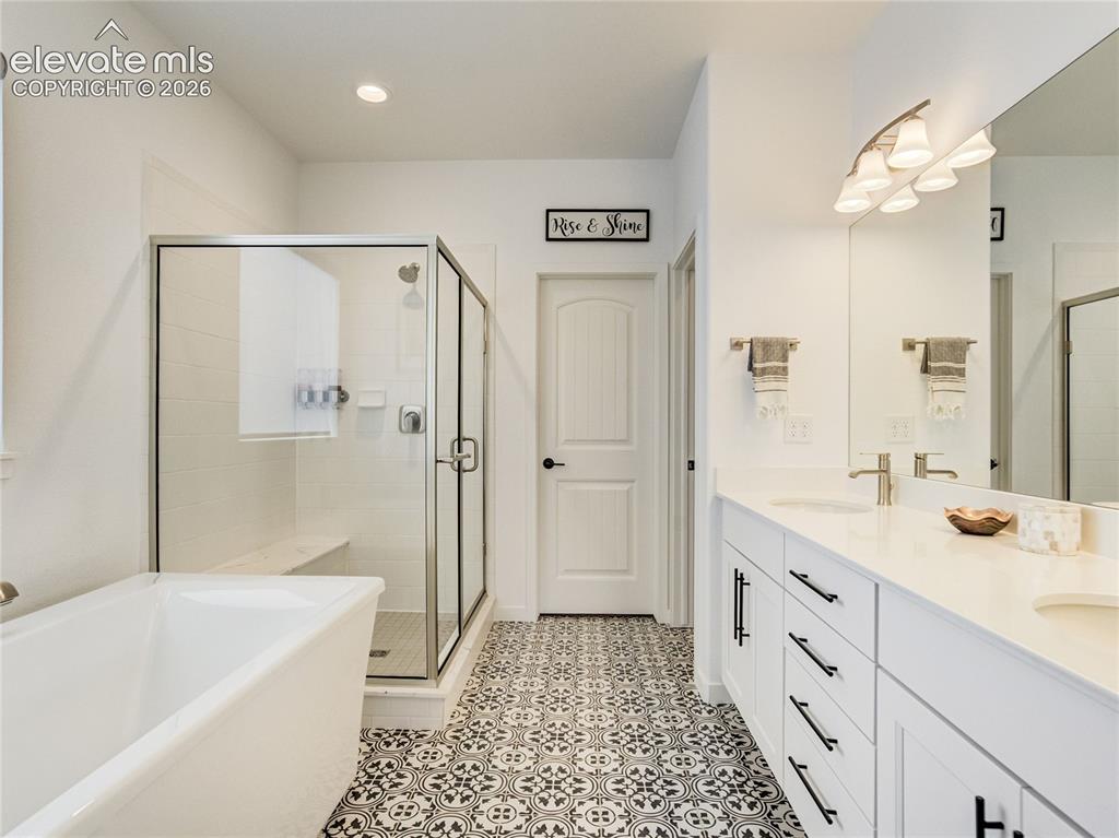 Image 6 of 50: 5-piece primary bath features a glass walled shower, double vanity & decora