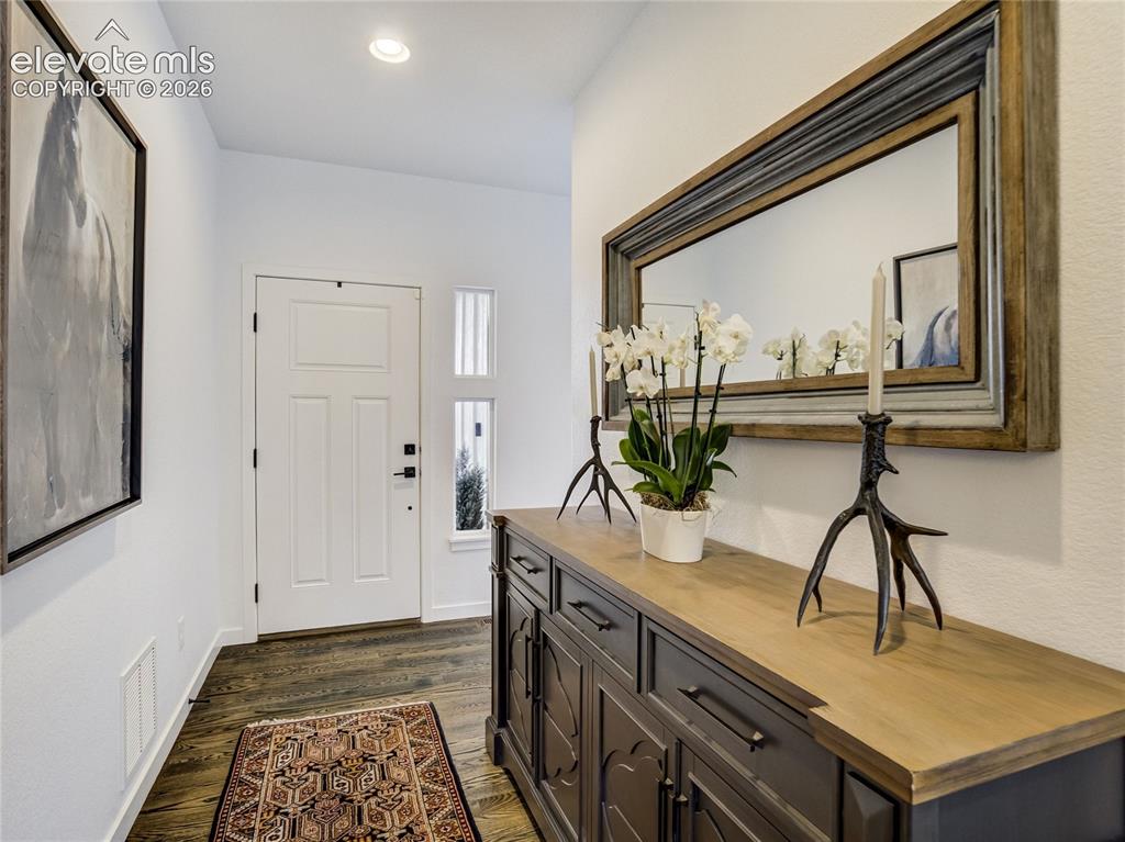 Image 9 of 50: Step in to a spacious foyer where warm toned wood floors & high ceilings cr