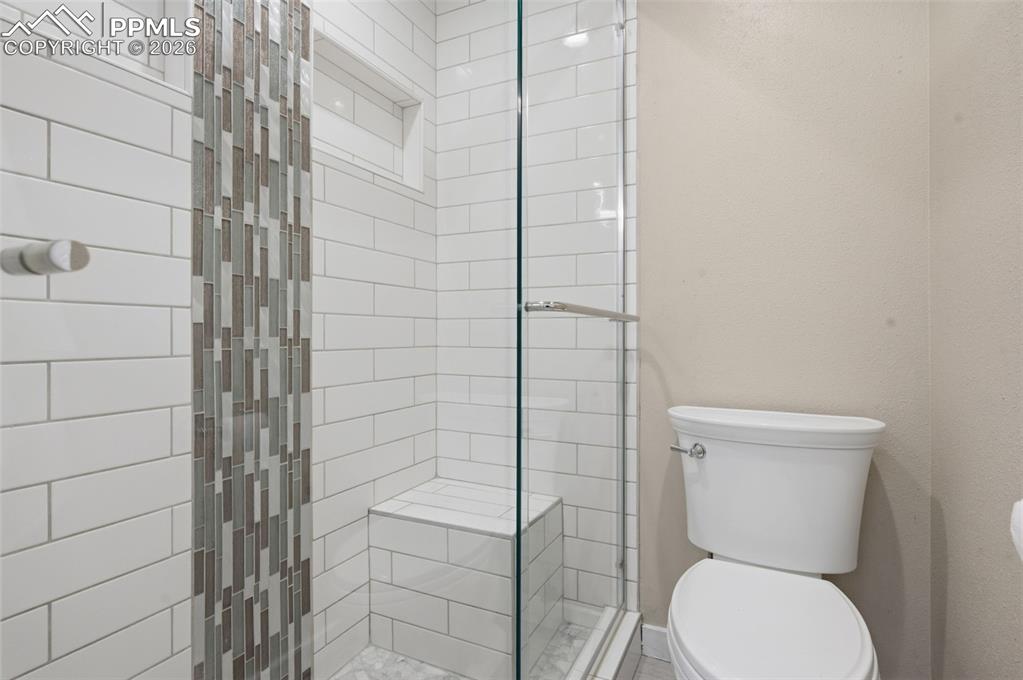 Image 35 of 50: Primary bathroom shower and toilet