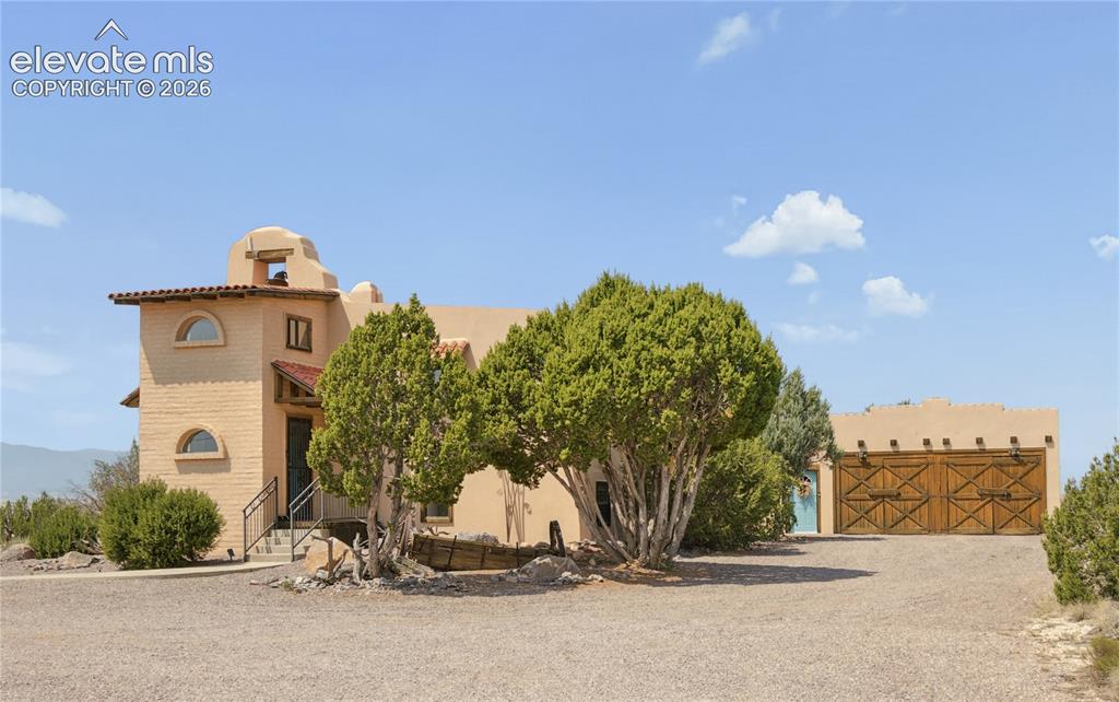 Image 1 of 38: Stucco exterior with arched windows, wrought iron railing, and a tile-roofe