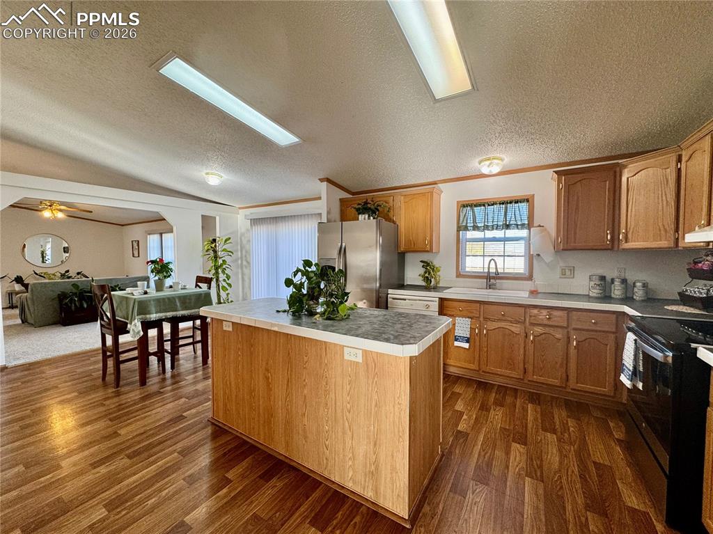 Image 11 of 44: Kitchen featuring wood finish cabinets, a center island, stainless steel ap