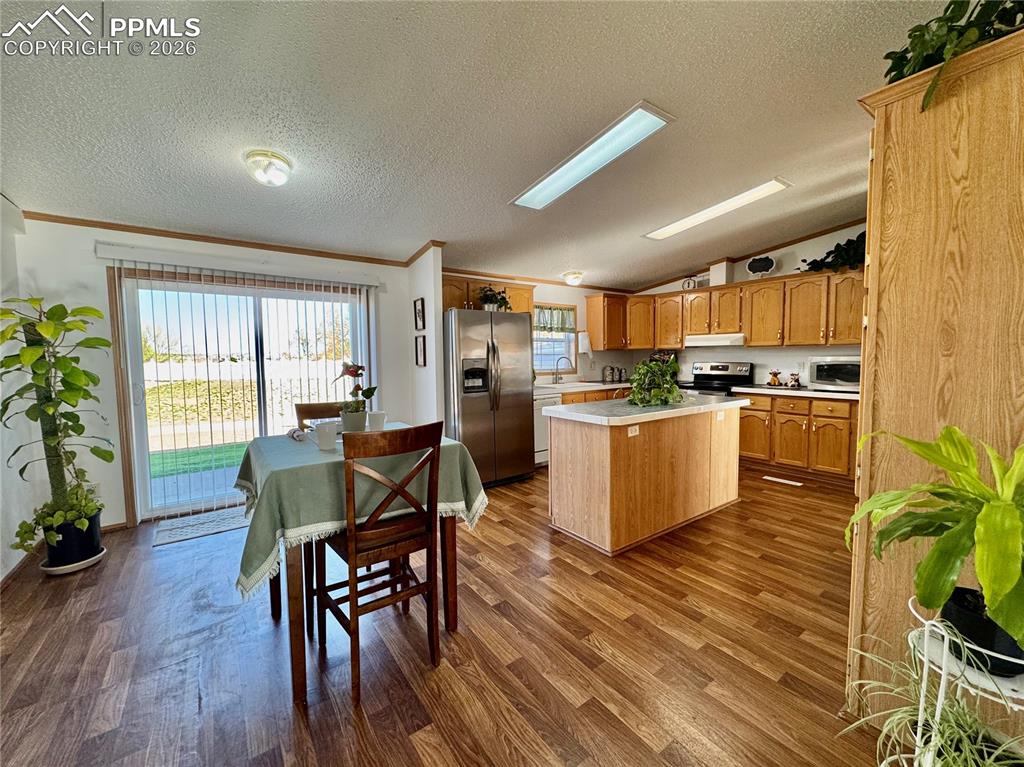 Image 15 of 44: Kitchen featuring light countertops, a kitchen island, stainless steel appl