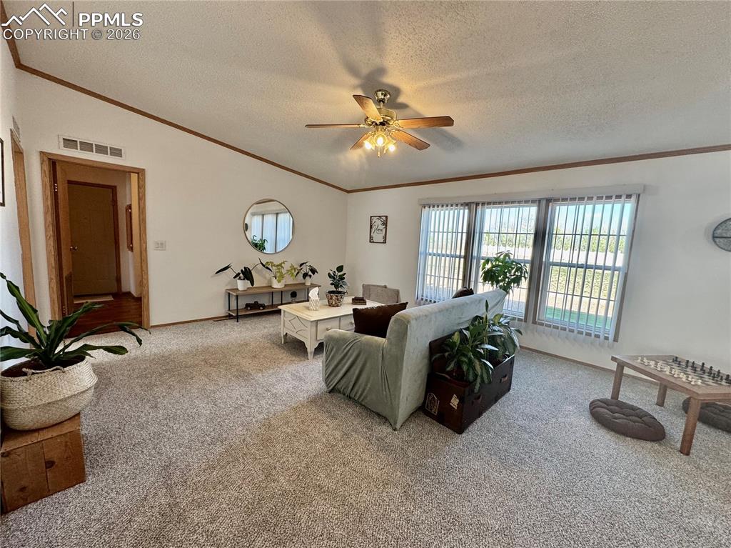 Image 18 of 44: Bedroom with carpet floors, ceiling fan, and ornamental molding