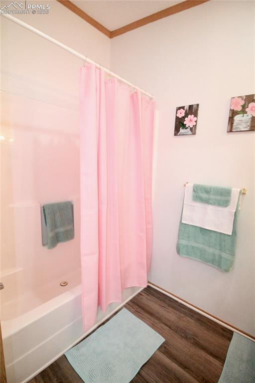 Image 23 of 44: Bathroom with dark wood finished floors, ornamental molding, and shower / b