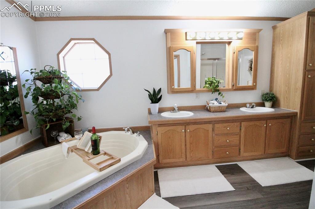 Image 28 of 44: Full bathroom featuring double vanity and a garden tub