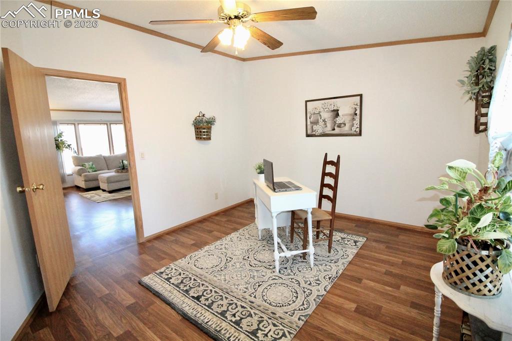Image 35 of 44: Office with dark wood finished floors, ceiling fan, and crown molding