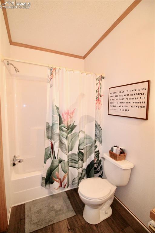 Image 38 of 44: Bathroom featuring ornamental molding, shower / tub combo, dark wood-style