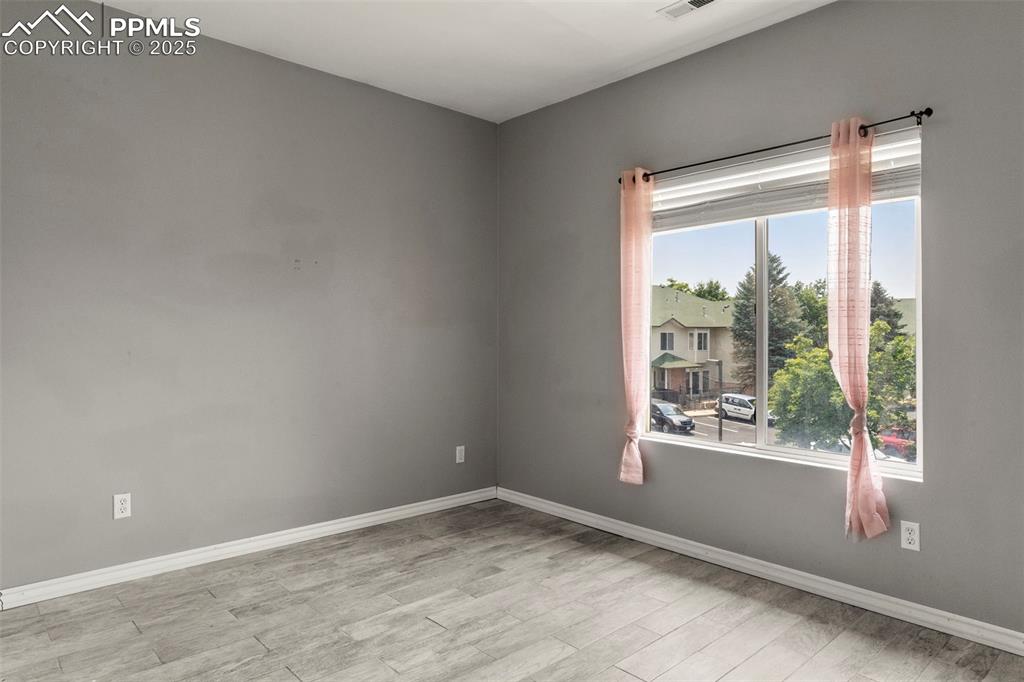 Image 11 of 15: Empty room with wood finished floors and baseboards