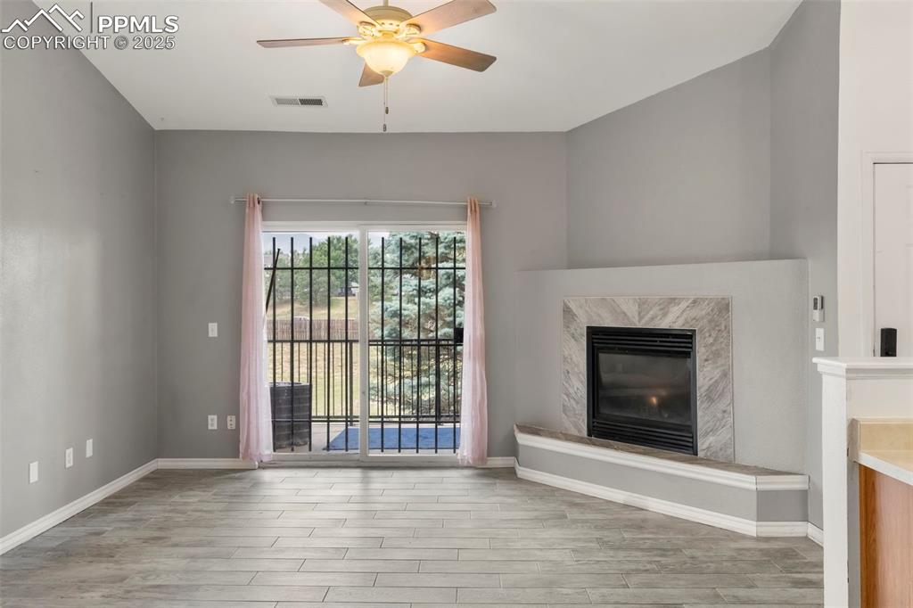 Image 3 of 15: Unfurnished living room featuring a premium fireplace, wood finished floors