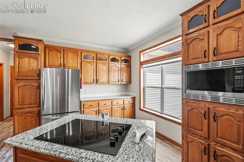 Image 19 of 41: Kitchen featuring ornamental molding, appliances with stainless steel finis