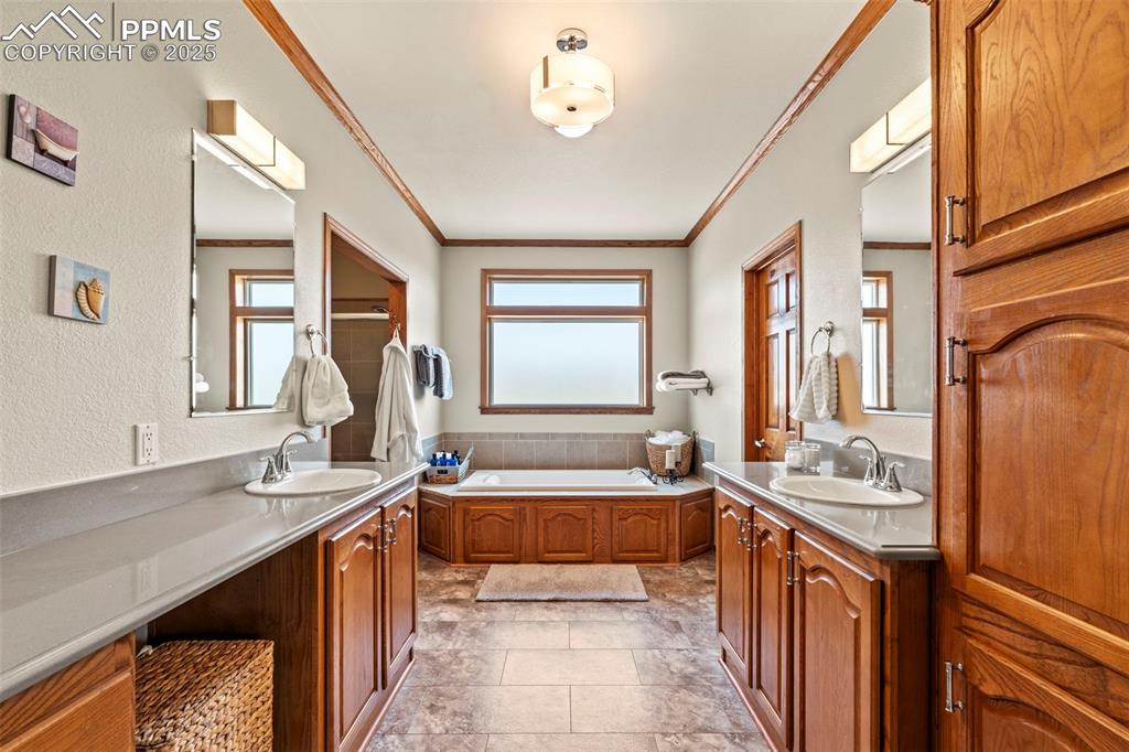 Image 27 of 41: Full bath featuring plenty of natural light, ornamental molding, two vaniti