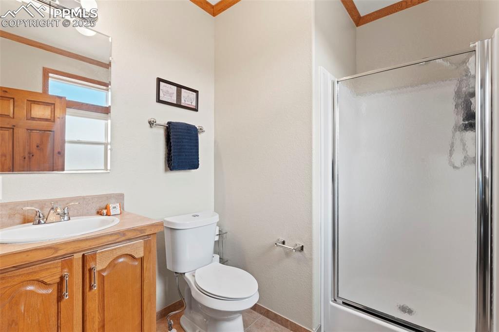 Image 32 of 41: Full bathroom featuring vanity, a stall shower, tile patterned floors, and