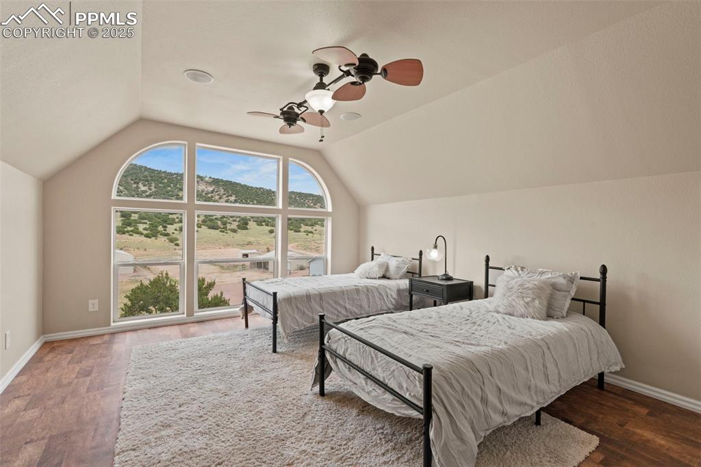 Image 36 of 41: Bedroom featuring vaulted ceiling, wood finished floors, and ceiling fan