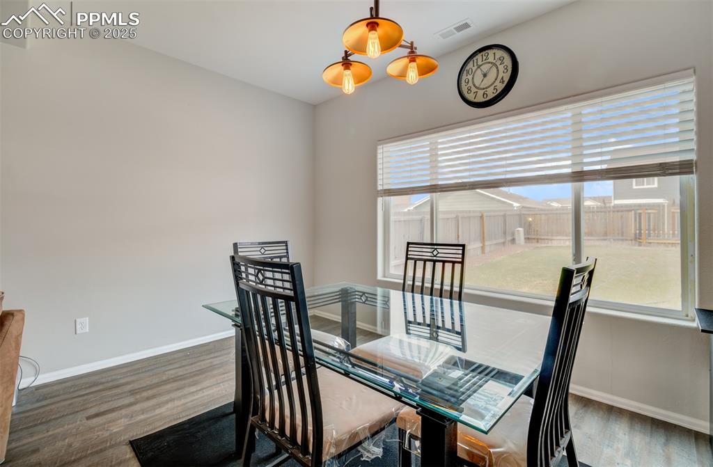 Image 10 of 35: Dining area with wood finished floors and baseboards