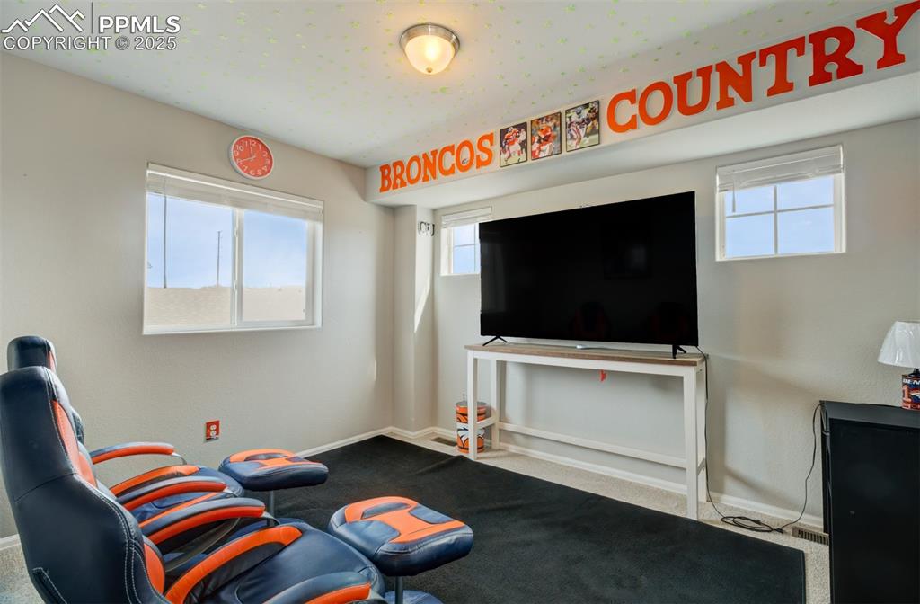 Image 20 of 35: Living area with baseboards and carpet