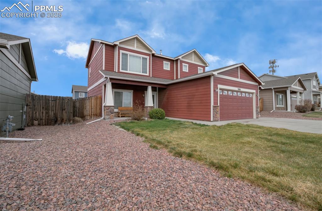 Image 30 of 35: Craftsman-style house with stone siding, an attached garage, and concrete d