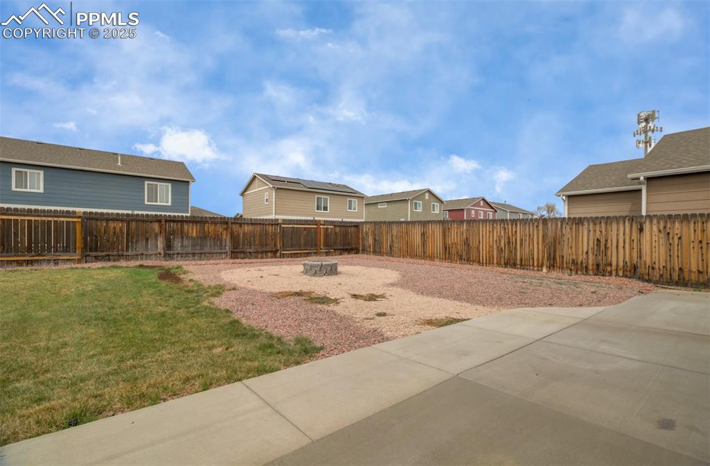 Image 35 of 35: Fenced backyard featuring a residential view and an outdoor fire pit