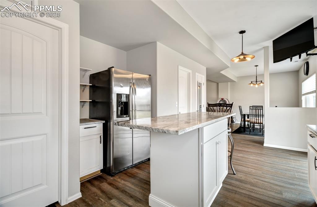 Image 7 of 35: Kitchen featuring white cabinets, stainless steel refrigerator with ice dis
