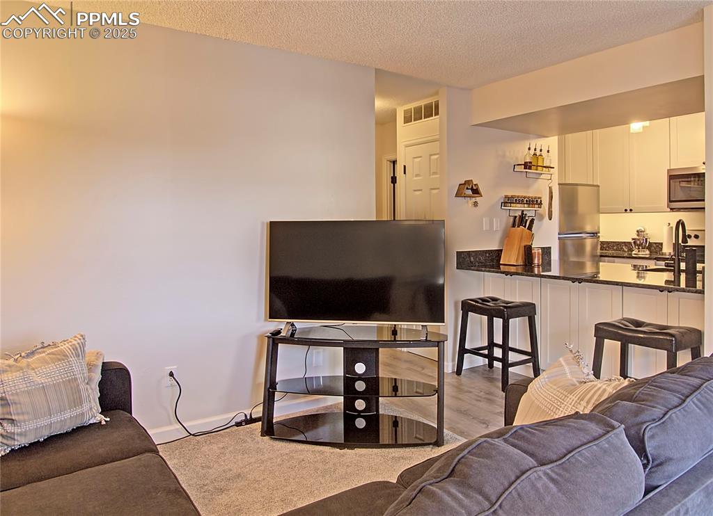 Image 5 of 30: Kitchen has breakfast bar with cabinets for underneath for additional stora