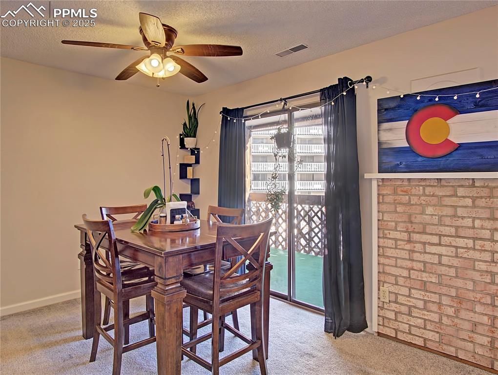 Image 9 of 30: Ceiling fan in dining space. Fireplace was covered years ago.