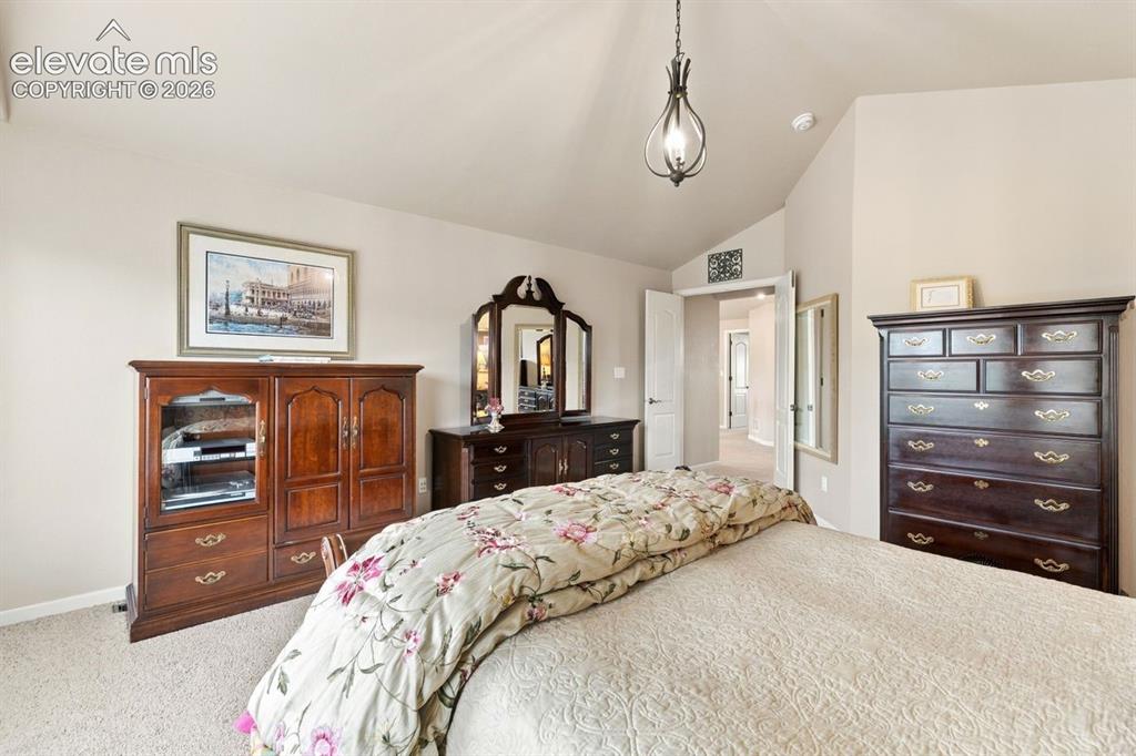 Image 17 of 50: Primary bedroom (upstairs bedroom #1) with vaulted ceiling and french doors