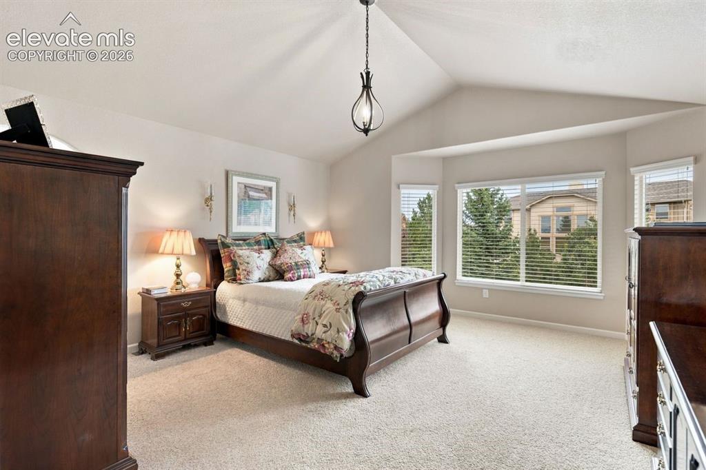 Image 18 of 50: Primary bedroom (upstairs bedroom #1) with vaulted ceiling and french doors