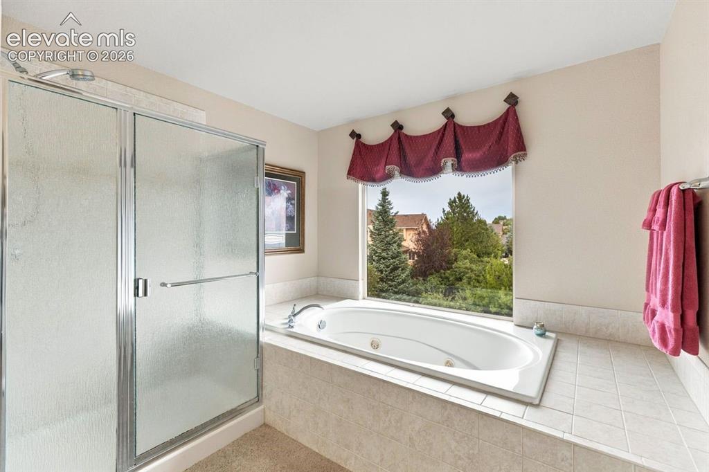 Image 20 of 50: Primary en suite 5-piece bathroom with oval jetted tub