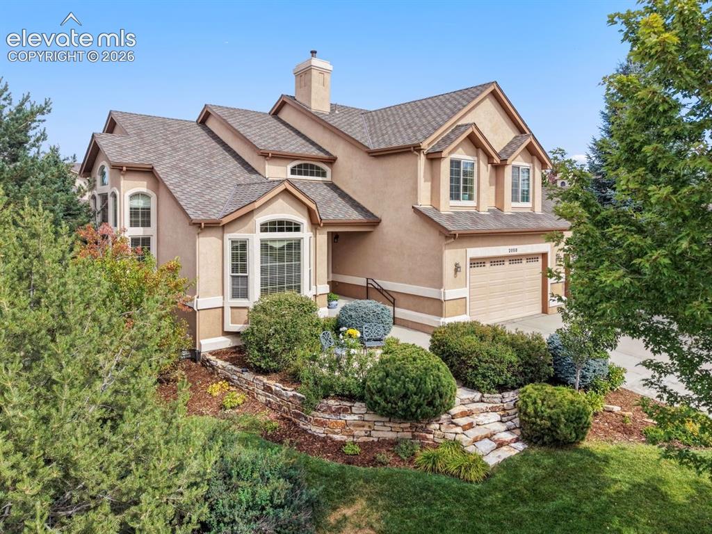 Image 36 of 50: Front of home with mature landscaping