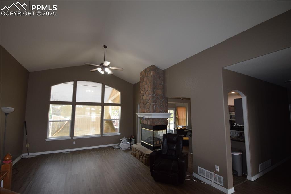 Image 10 of 50: Living room featuring wood finished floors, a ceiling fan, vaulted ceiling,