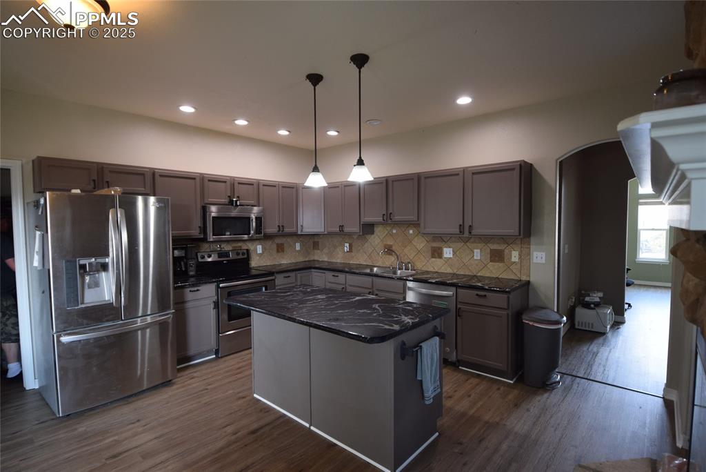 Image 12 of 50: Kitchen with appliances with stainless steel finishes, decorative backsplas