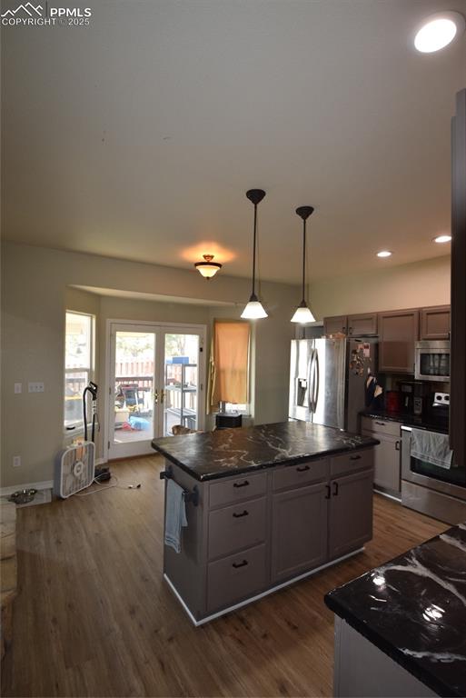 Image 17 of 50: Kitchen with dark wood-style floors, range, a kitchen island, refrigerator,