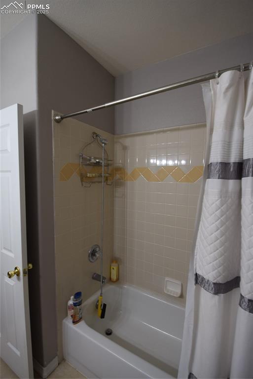 Image 21 of 50: Bathroom featuring shower / bath combination with curtain