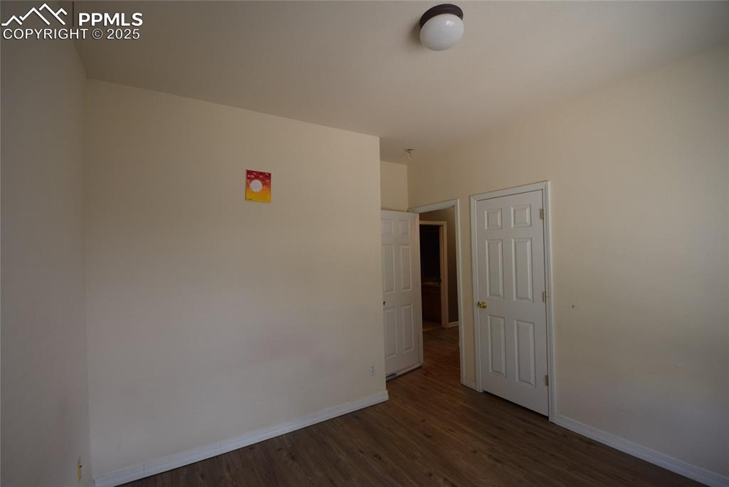 Image 27 of 50: Unfurnished room with baseboards and wood finished floors