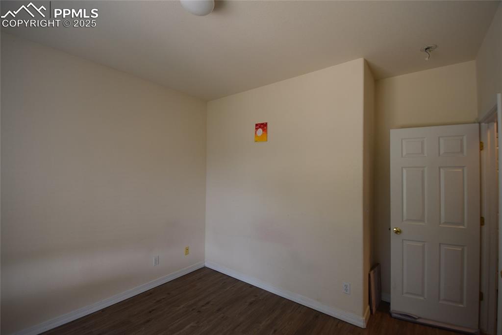 Image 28 of 50: Spare room featuring dark wood finished floors and baseboards