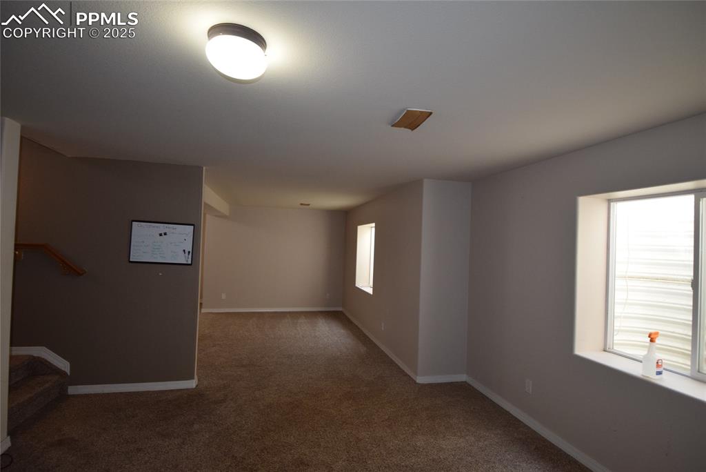 Image 39 of 50: Empty room featuring carpet and baseboards