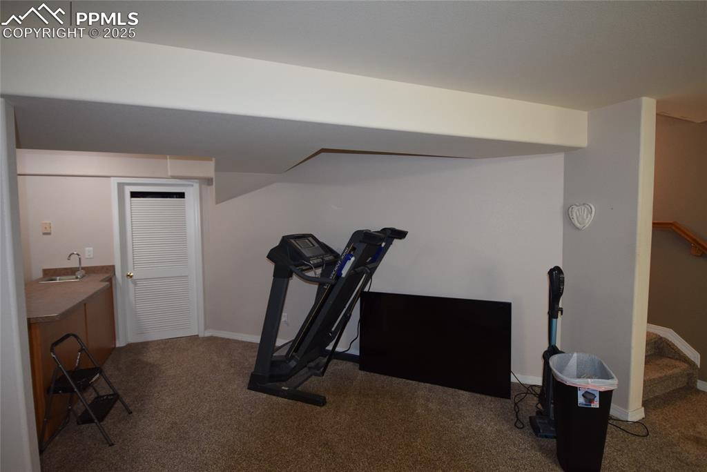 Image 41 of 50: Exercise room featuring carpet and baseboards