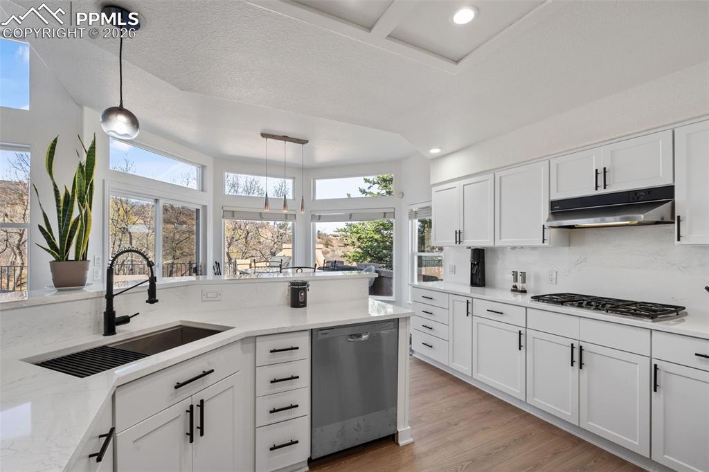 Image 15 of 49: Kitchen featuring light stone countertops, white cabinets, and decorative l